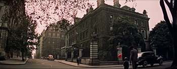 Movie still from “The Eddy Duchin Story” (1956), directed by George Sidney – A person standing in front of a building on a street; Extreme Wide shot, Low angle
