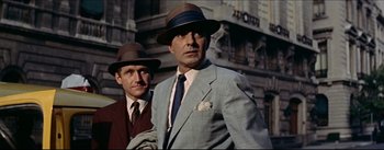 Movie still from “The Eddy Duchin Story” (1956), directed by George Sidney – A man in a suit and a man in a hat and tie; Medium shot, Low angle