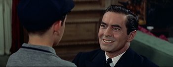 Movie still from “The Eddy Duchin Story” (1956), directed by George Sidney – A man in a suit and a hat talking to another man in a suit; Close Up shot, Over the shoulder angle