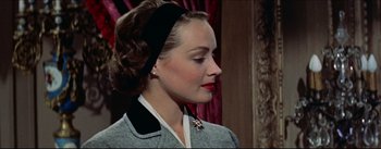 Movie still from “The Eddy Duchin Story” (1956), directed by George Sidney – A woman wearing a black headband and a gray jacket; Close Up shot, Low angle