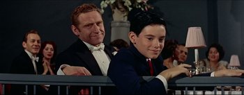 Movie still from “The Eddy Duchin Story” (1956), directed by George Sidney – A man and a young boy sitting next to each other; Medium shot, Over the shoulder angle