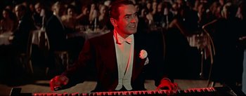 Movie still from “The Eddy Duchin Story” (1956), directed by George Sidney – A man in a tuxedo is sitting at a piano; Medium shot, Low angle