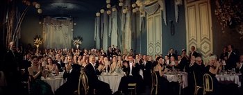 Movie still from “The Eddy Duchin Story” (1956), directed by George Sidney – A group of people sitting at tables in formal wear; Wide shot, Low angle