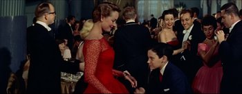 Movie still from “The Eddy Duchin Story” (1956), directed by George Sidney – A woman in a red dress and a man in a suit; Medium shot, Low angle