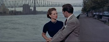 Movie still from “The Eddy Duchin Story” (1956), directed by George Sidney – A man and a woman standing next to a body of water; Medium shot, High angle