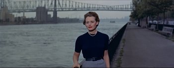 Movie still from “The Eddy Duchin Story” (1956), directed by George Sidney – A woman standing in front of a body of water; Medium shot, Low angle