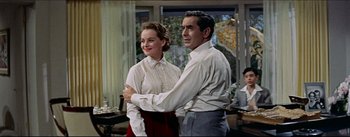 Movie still from “The Eddy Duchin Story” (1956), directed by George Sidney – A man and a woman standing next to each other in a room; Medium shot, Low angle