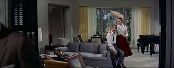 Movie still from “The Eddy Duchin Story” (1956), directed by George Sidney – A man and a woman in a living room; Wide shot, Low angle