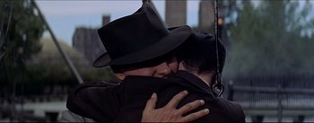 Movie still from “The Eddy Duchin Story” (1956), directed by George Sidney – Two men hugging each other in front of a city skyline; Close Up shot, Over the shoulder angle