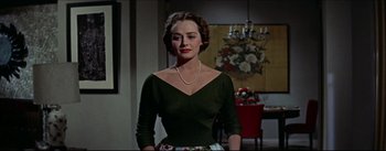 Movie still from “The Eddy Duchin Story” (1956), directed by George Sidney – A woman in a black top and a floral skirt; Medium shot, Low angle