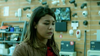 Movie still from “The Empty Man” (2020), directed by David Prior – A woman in brown jacket looking down in a store; Close Up shot, Low angle