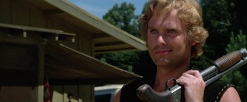 Movie still from “The Enforcer” (1976), directed by James Fargo – A person holding a wrench near a building; Close Up shot, Low angle