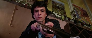 Movie still from “The Enforcer” (1976), directed by James Fargo – A man is holding a gun in his hands; Close Up shot, Low angle