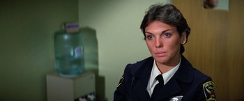 Movie still from “The Enforcer” (1976), directed by James Fargo – A female police officer in uniform looking into the camera; Close Up shot, Over the shoulder angle