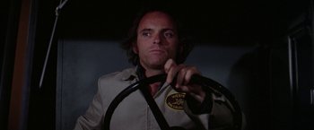Movie still from “The Enforcer” (1976), directed by James Fargo – A man holding a steering wheel in a dark room; Close Up shot, Low angle