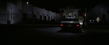 Movie still from “The Enforcer” (1976), directed by James Fargo – A car parked in front of a building at night; Extreme Wide shot, Low angle