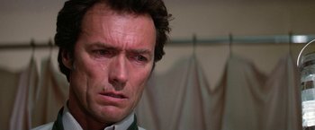Movie still from “The Enforcer” (1976), directed by James Fargo – A man's face in a white shirt; Close Up shot, Low angle