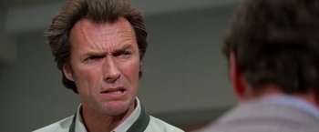 Movie still from “The Enforcer” (1976), directed by James Fargo – A person wearing a white shirt; Close Up shot, Low angle