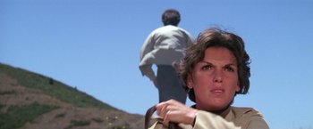 Movie still from “The Enforcer” (1976), directed by James Fargo – A woman standing next to a man on top of a hill; Close Up shot, Low angle