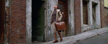 Movie still from “The Enforcer” (1976), directed by James Fargo – A woman holding a briefcase while walking down the street; Wide shot, Low angle