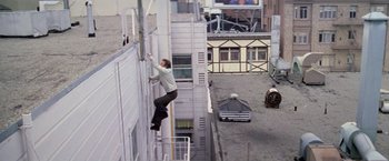 Movie still from “The Enforcer” (1976), directed by James Fargo – A man climbing up the side of a tall building; Wide shot, High angle