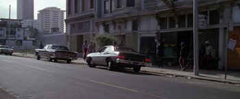 Movie still from “The Enforcer” (1976), directed by James Fargo – A car parked on the side of the street; Wide shot, High angle