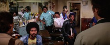 Movie still from “The Enforcer” (1976), directed by James Fargo – A group of men sitting in a room; Medium shot, Over the shoulder angle