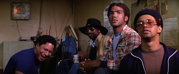 Movie still from “The Enforcer” (1976), directed by James Fargo – Two men sitting next to each other in a room; Medium shot, Low angle