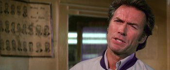 Movie still from “The Enforcer” (1976), directed by James Fargo – A person wearing a white shirt; Close Up shot, Low angle