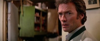 Movie still from “The Enforcer” (1976), directed by James Fargo – A man's face in front of a bookshelf; Close Up shot, Over the shoulder angle