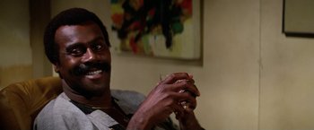 Movie still from “The Enforcer” (1976), directed by James Fargo – A person holding a cell phone; Close Up shot, Low angle