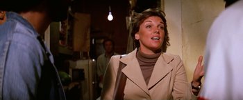 Movie still from “The Enforcer” (1976), directed by James Fargo – A woman wearing a tan coat and a brown sweater; Close Up shot, Low angle