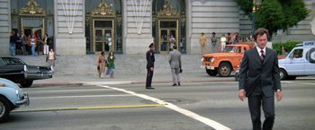 Movie still from “The Enforcer” (1976), directed by James Fargo – A police officer standing on the side of the street; Extreme Wide shot, High angle