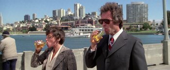 Movie still from “The Enforcer” (1976), directed by James Fargo – A man and a woman are standing by the water; Medium shot, Low angle