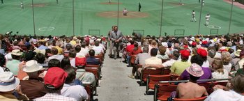 Movie still from “The Enforcer” (1976), directed by James Fargo – A group of people sitting on top of a stadium bench; Extreme Wide shot, High angle