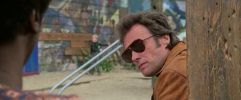 Movie still from “The Enforcer” (1976), directed by James Fargo – A person wearing sunglasses; Close Up shot, Low angle