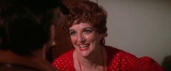 Movie still from “The Enforcer” (1976), directed by James Fargo – A person wearing a red dress; Close Up shot, Over the shoulder angle