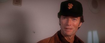 Movie still from “The Enforcer” (1976), directed by James Fargo – A person wearing a baseball cap; Close Up shot, Over the shoulder angle