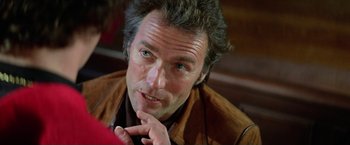 Movie still from “The Enforcer” (1976), directed by James Fargo – A person with his hand on his chin; Close Up shot, Over the shoulder angle