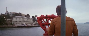 Movie still from “The Enforcer” (1976), directed by James Fargo – A man looking through a fire hydrant on a boat; Wide shot, Low angle