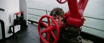 Movie still from “The Enforcer” (1976), directed by James Fargo – A person with a gun pointed at the camera; Medium shot, Low angle