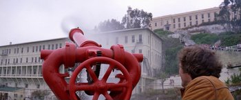 Movie still from “The Enforcer” (1976), directed by James Fargo – A red fire hydrant in front of a building; Extreme Wide shot, Low angle