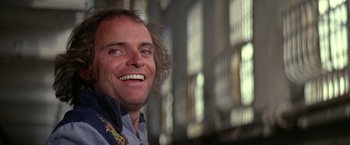Movie still from “The Enforcer” (1976), directed by James Fargo – A person smiling; Close Up shot, Low angle
