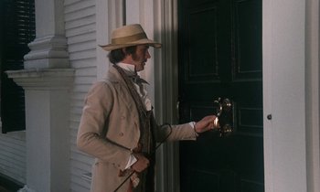 Movie still from “The Europeans” (1979), directed by James Ivory – A man wearing a hat and holding a key to a door; Medium shot, High angle