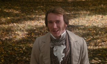 Movie still from “The Europeans” (1979), directed by James Ivory – A man in a suit and tie standing in front of leaves; Close Up shot, Over the shoulder angle