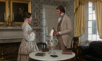 Movie still from “The Europeans” (1979), directed by James Ivory – A man and a woman standing next to each other in a room; Medium shot, High angle