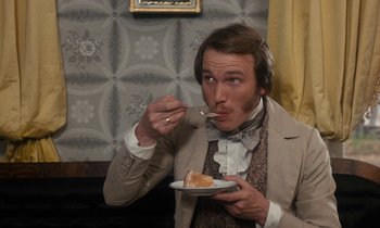 Movie still from “The Europeans” (1979), directed by James Ivory – A man wearing a suit and eating a piece of cake; Close Up shot, Over the shoulder angle