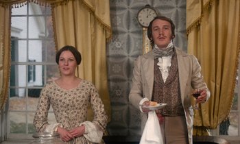 Movie still from “The Europeans” (1979), directed by James Ivory – A man and a woman standing next to each other holding plates; Medium shot, Low angle