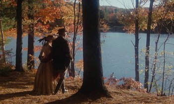 Movie still from “The Europeans” (1979), directed by James Ivory – A man and a woman standing next to each other near a lake; Wide shot, High angle