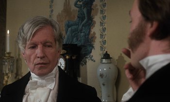 Movie still from “The Europeans” (1979), directed by James Ivory – A man in a suit and tie looking into a mirror; Close Up shot, Over the shoulder angle